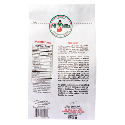 Back of a 12 oz Mi Niña Tortilla “Jalapeño Agave” Chip bag from the 9 Pack, showing nutrition, ingredients, brand story, and contact info. The design has a circular logo with a girl and text in English and Spanish.
