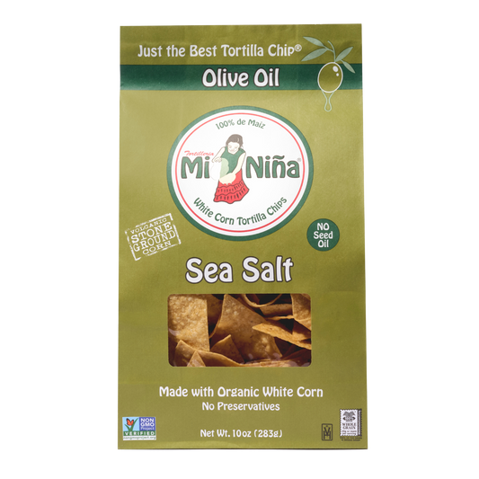 A green box of Mi Niña Tortilla Sea Salt Made with Olive Oil Tortilla Chips (9 Pack / 10 oz) displays chips through a clear window and features 100% de maíz, No Seed Oil, and Made with Organic White Corn.