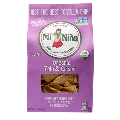 A 10 oz bag of Mi Niña Tortilla Organic Thin & Crispy Sea Salt Tortilla Chips comes in purple packaging with USDA Organic, Non-GMO, and gluten free labels, letting you see the crispy chips inside.